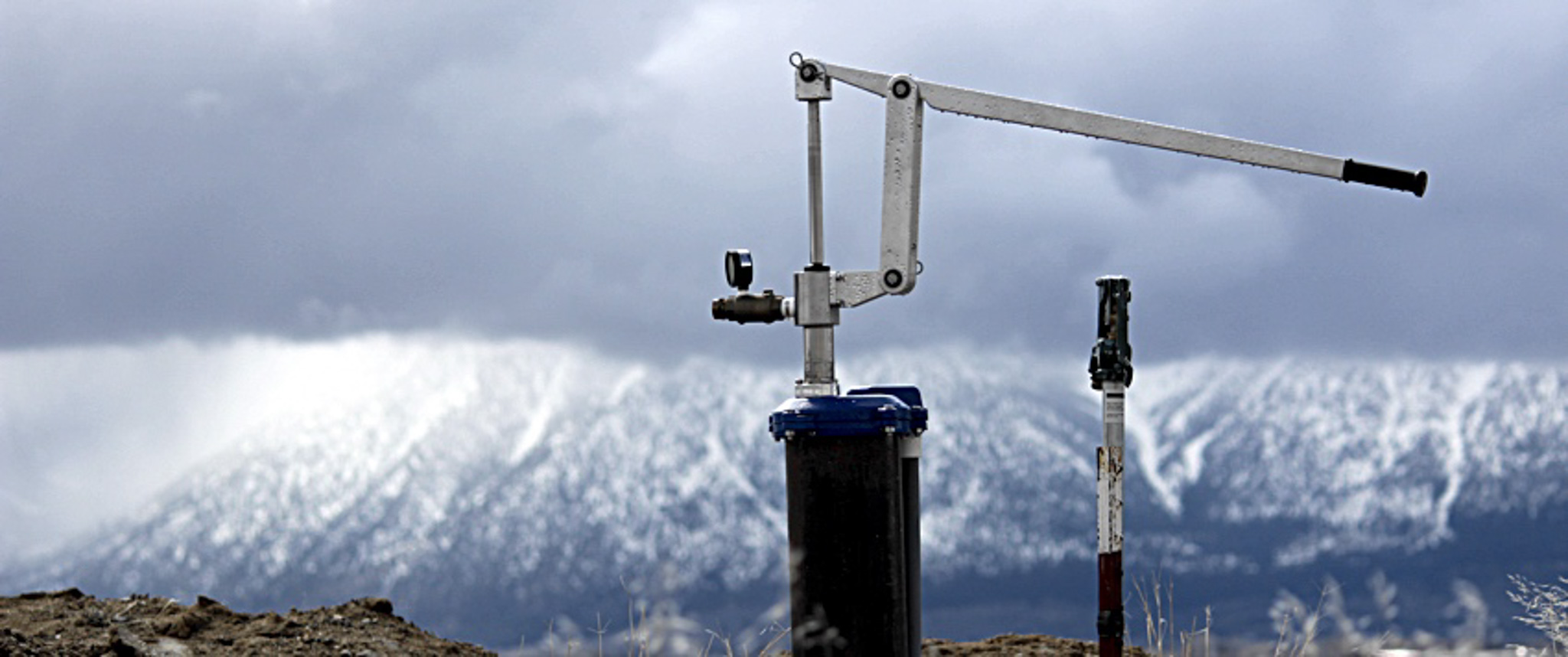 Simple pump against mountain background - An off-grid installation process by Amber Water Pros.